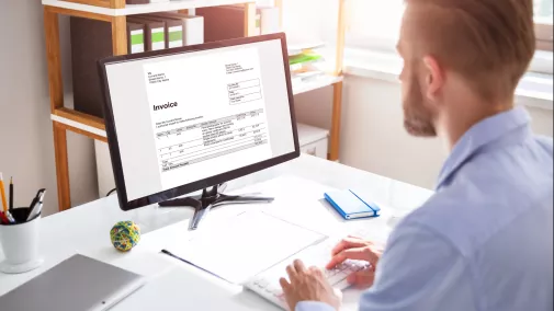 Mann sitzt am Computer im Büro